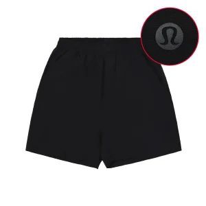 Black polyester shorts with elastic waistband and icon detail on fabric.