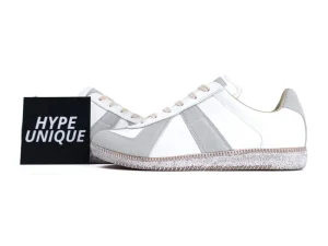 White leather and grey suede sneakers with textured rubber sole and beige laces.
