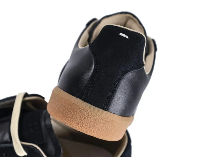 Black leather shoe with a suede heel and a gum rubber sole.