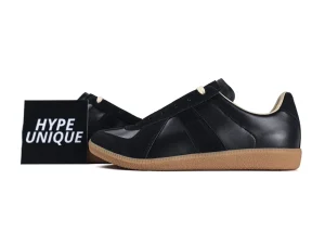 Black leather sneakers with gum sole, featuring suede accents and beige lining.