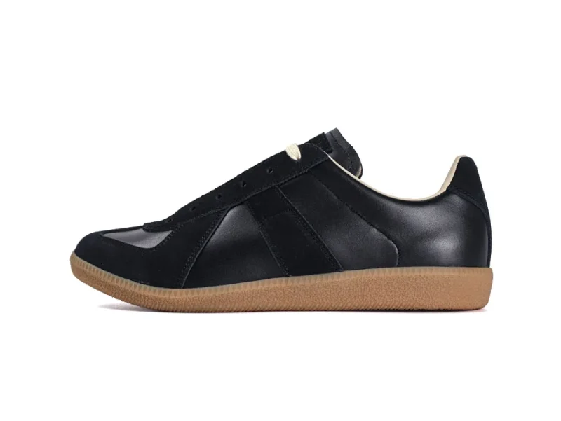 Black leather sneaker with a beige rubber sole and cream accents.
