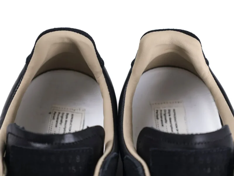 Black leather shoes with beige interior lining, close-up view of the heel area.