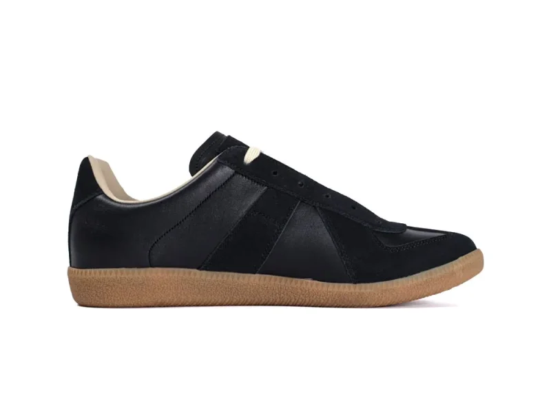 Black leather and suede sneaker with gum rubber sole, side view.