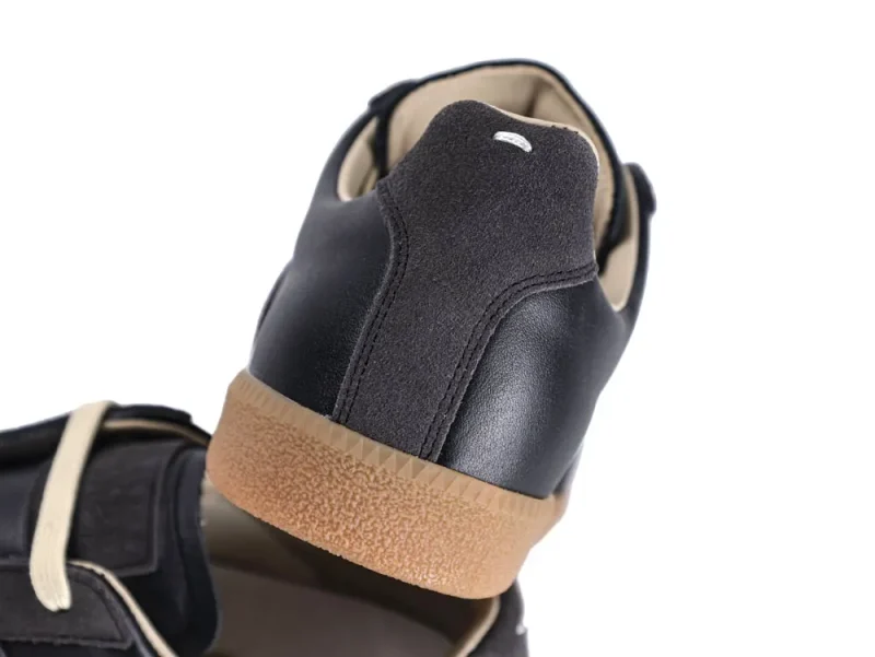 Black leather and suede sneaker heel with light brown rubber sole.