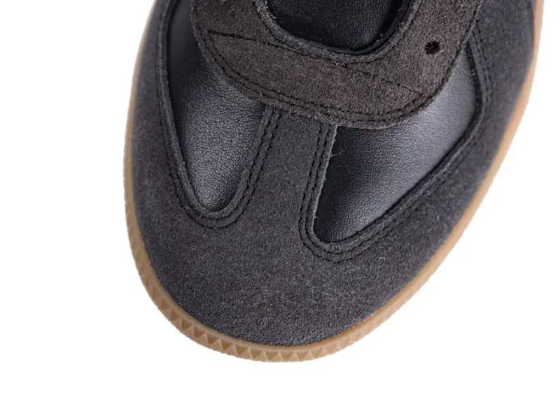 Close-up of a black and brown leather and suede sneaker with gum sole.