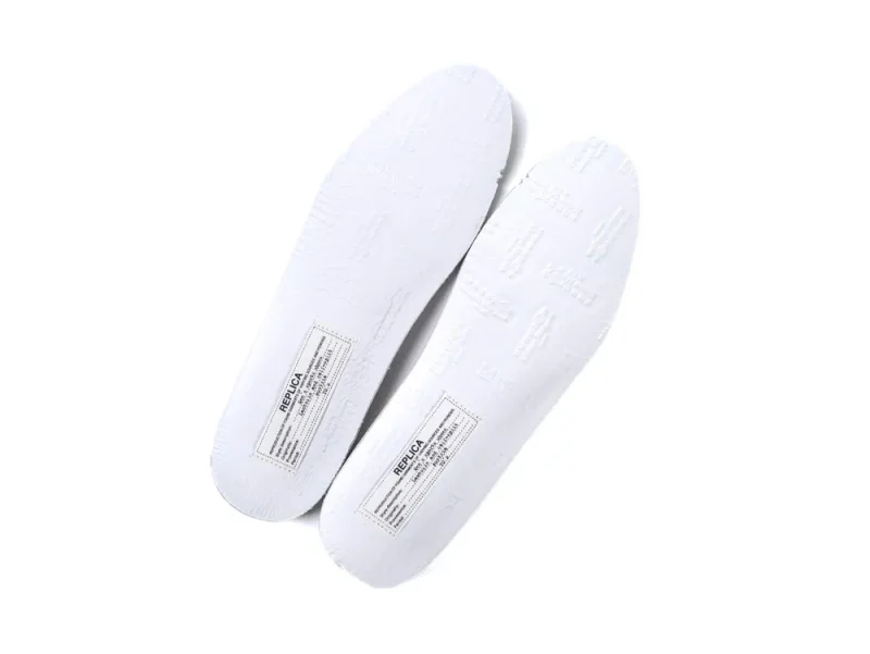 White rubber shoe soles with embossed texture and label details.
