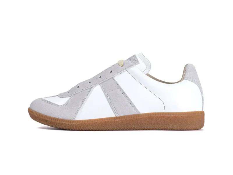 White and gray suede sneaker with brown rubber sole and lace-up closure.
