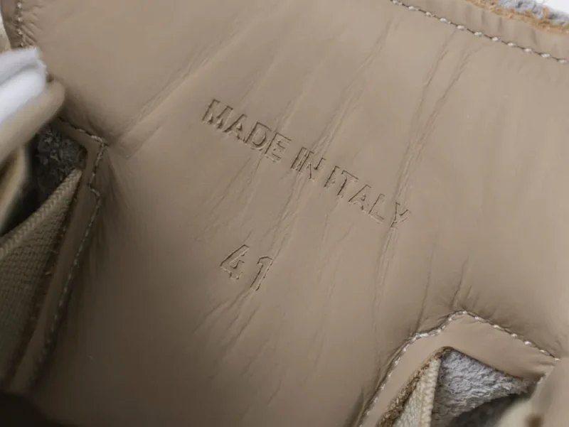 Beige leather interior of a shoe with "Made in Italy" embossed.