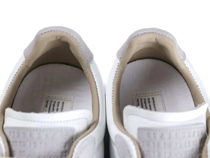 White leather sneaker interiors with beige lining and gray suede details.
