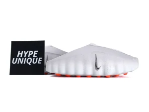 White synthetic sneakers with an orange sole and a metallic logo accent.