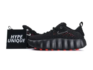 Black sneaker with textured material, featuring a unique cushioned sole and red accents.