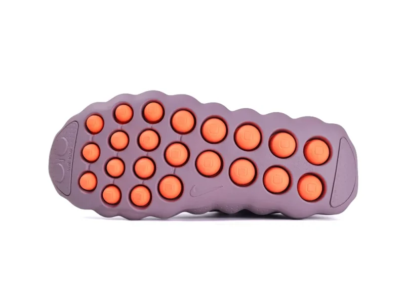 Purple and orange rubber sole of a shoe with circular grip pattern.