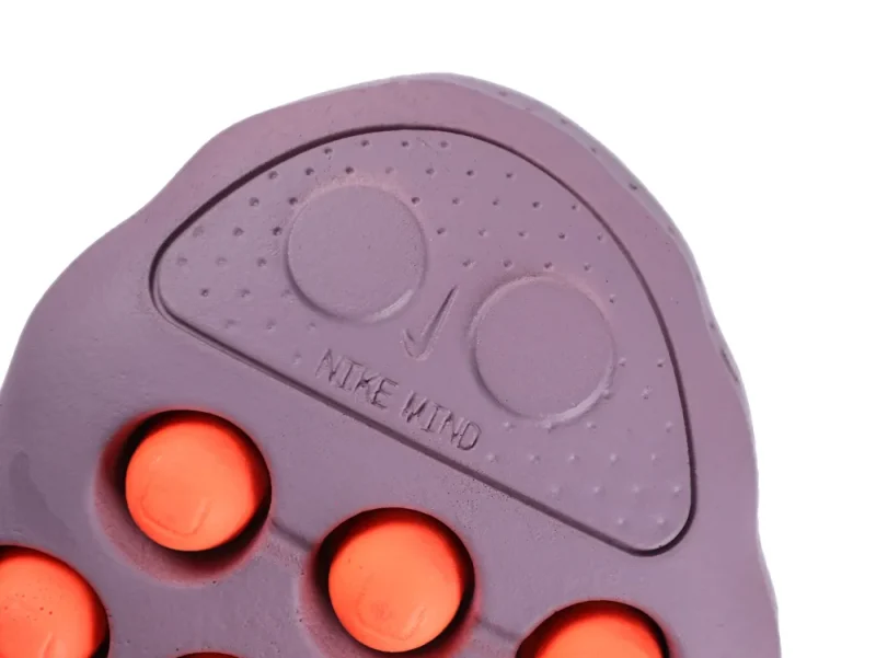 Purple rubber shoe sole with red circular accents and textured design.