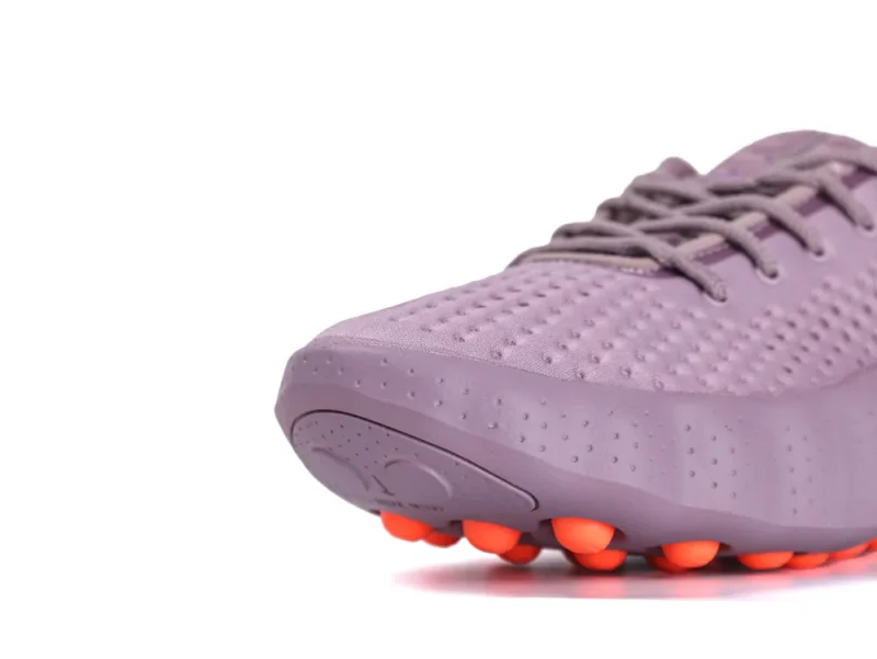 Purple sneaker with textured fabric upper and orange rubber sole accents.