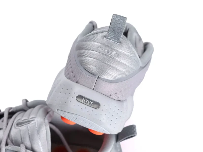 Gray mesh sneakers with perforated details and orange accents, featuring the heel area.