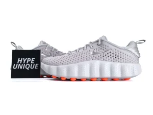 Gray perforated sneakers with orange soles and silver accents.