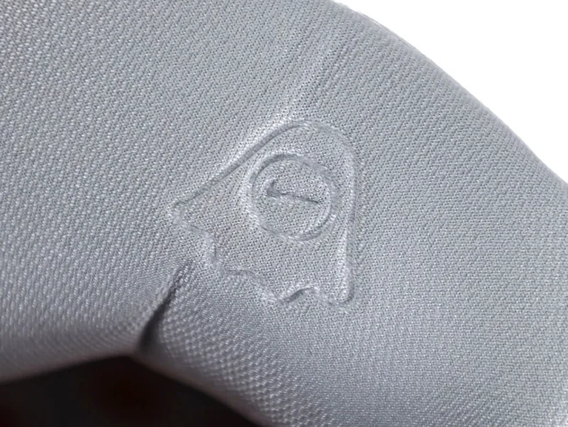 Close-up of a gray fabric material with an embossed design pattern.