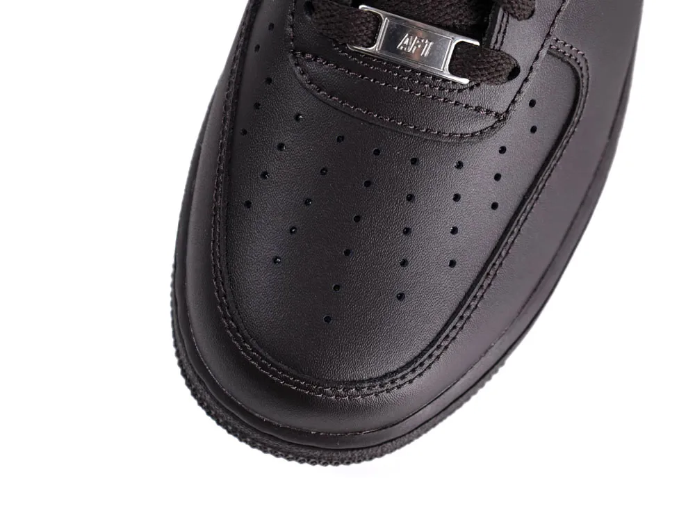 Close-up of dark brown leather shoe toe with perforated design and metal lace detail.