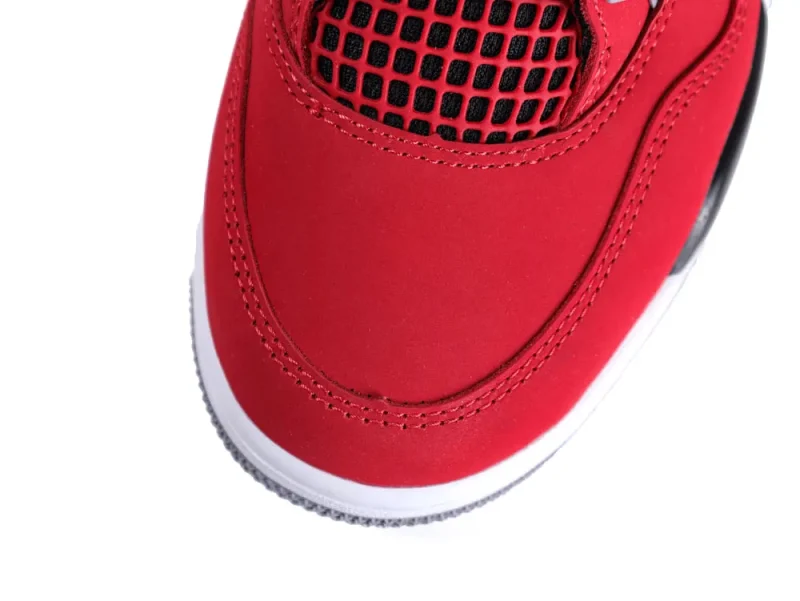 Red sneaker toe with black mesh and white sole, showcasing stitched leather details.