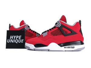 Red suede sneakers with black mesh and plastic accents, featuring a white rubber sole.