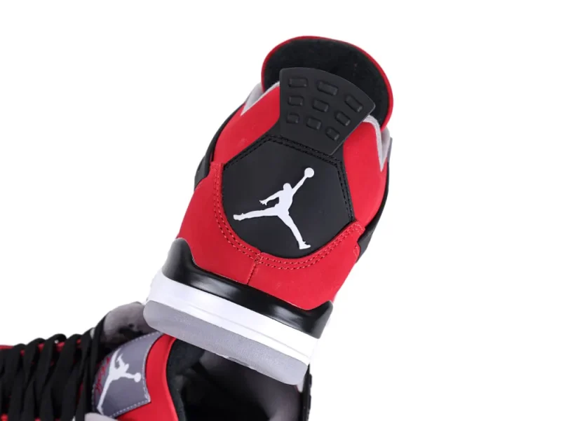 Red and black sneaker with rubber sole, featuring suede and leather materials.