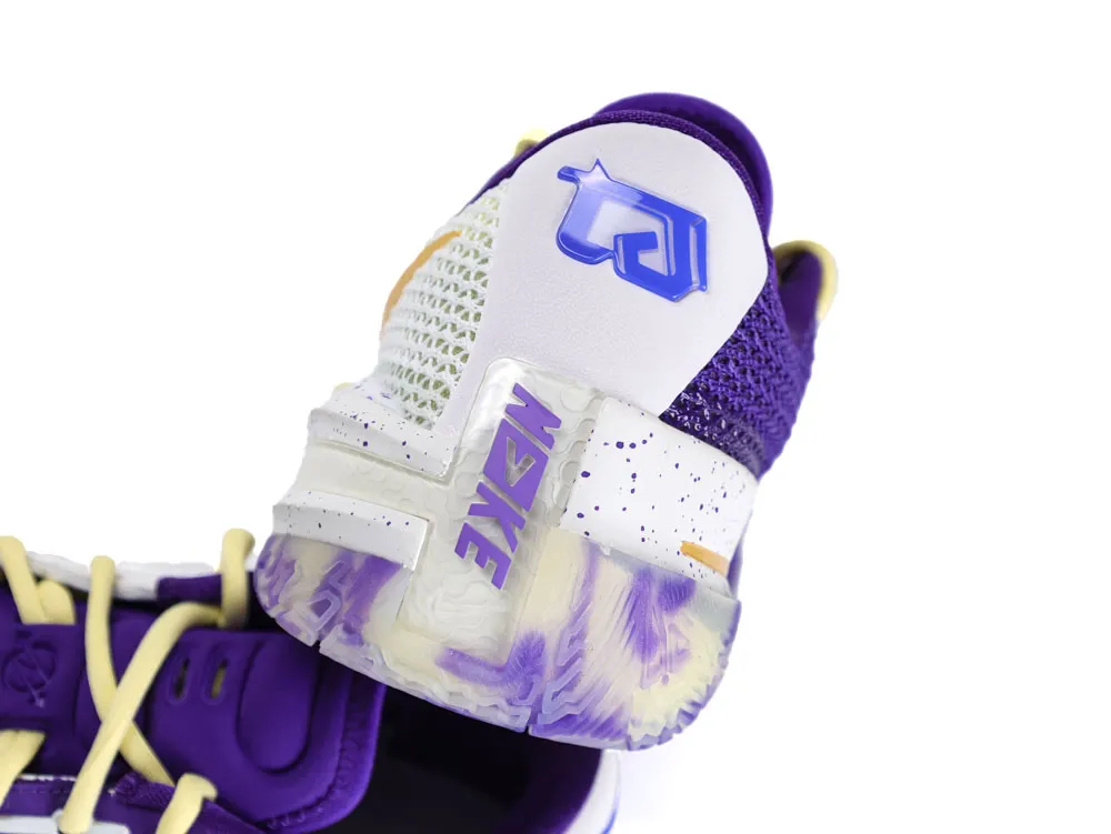 Purple and white shoe with mesh material and speckled midsole detail.
