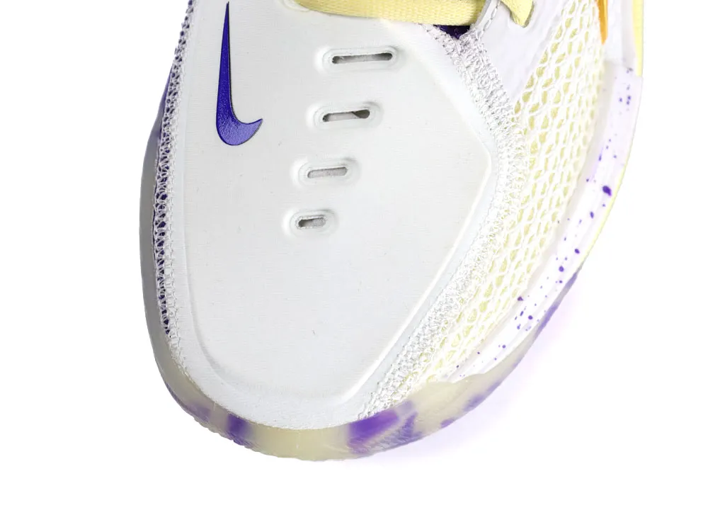 White sneaker toe with purple accents, mesh material, and a speckled translucent sole.