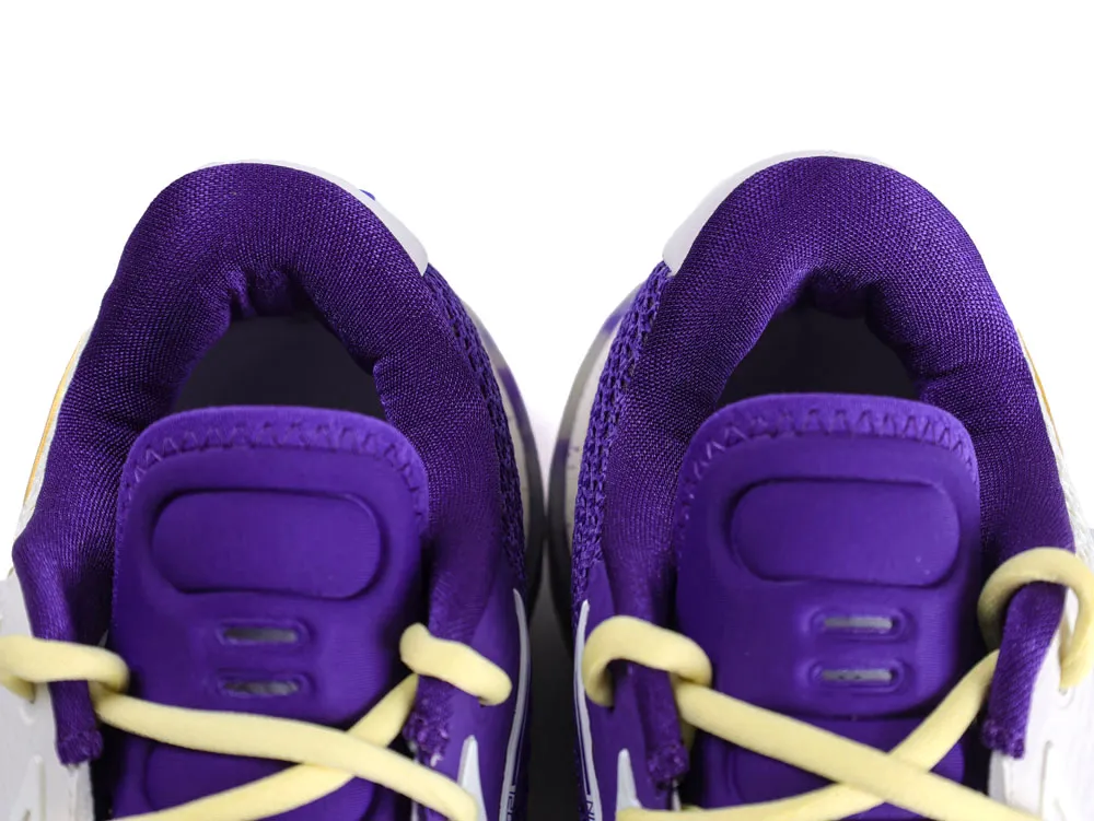 Purple fabric sneakers with white and yellow laces, viewed from the top.