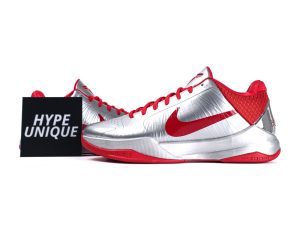 Silver and red sneakers with synthetic upper material and rubber sole, featuring logo.