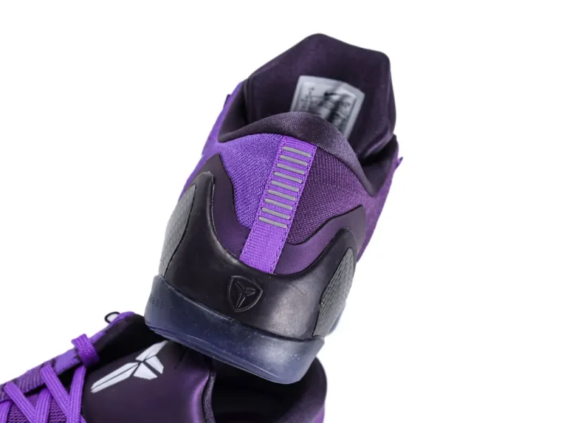 Purple fabric shoe with black rubber sole, featuring mesh and plastic heel detail.