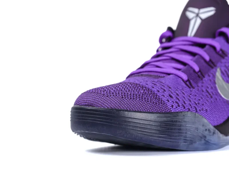 Purple knit sneaker with a black rubber sole and purple laces, close-up view.