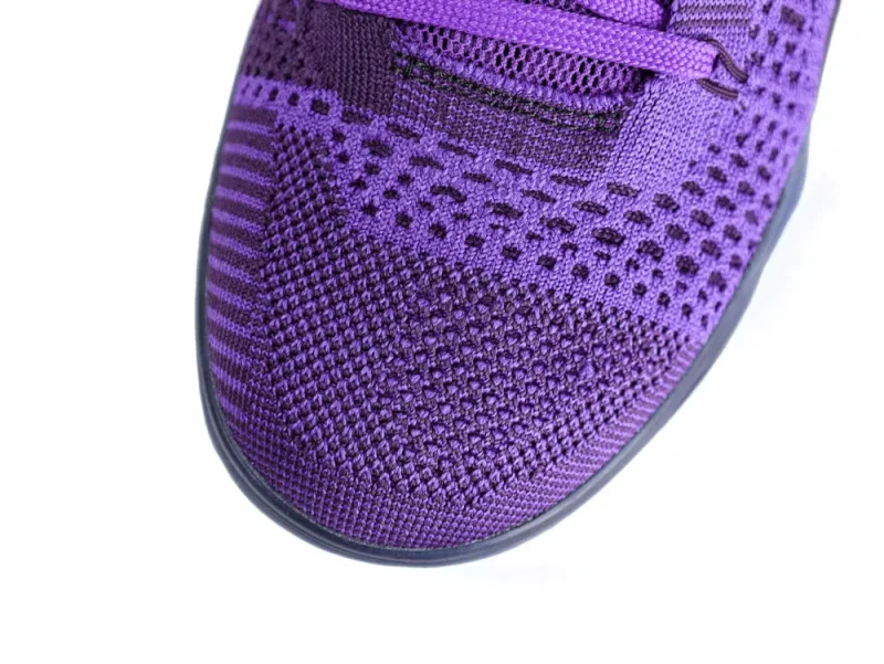 Close-up of a purple knit textile sneaker upper with decorative patterns.