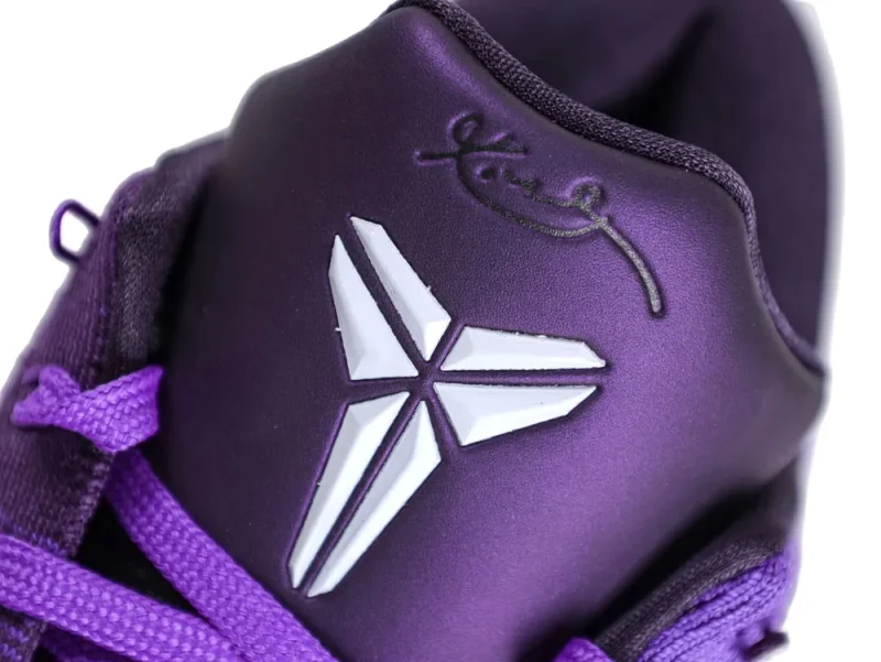 Close-up of a purple synthetic shoe tongue with white logo and laces.