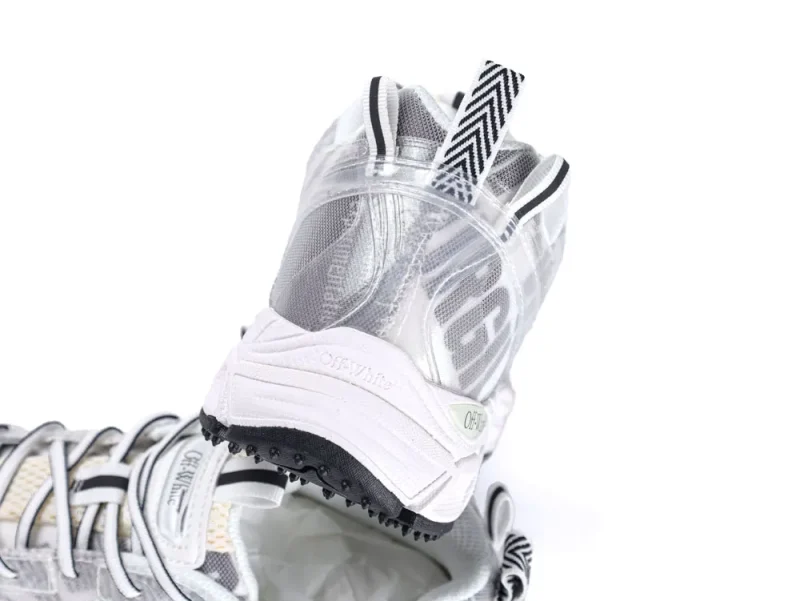 White and gray sneaker with mesh material, featuring black and white patterned pull-loop.