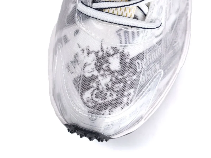 Close-up of a white mesh sneaker toe with black graffiti-style patterns.