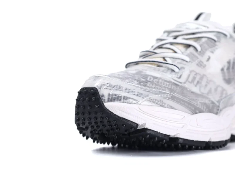 White and transparent sneaker with textured black rubber sole, featuring a mesh upper.