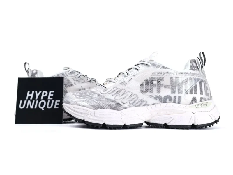 White sneakers with text pattern, mesh material, rubber sole, and lace-up fastening.