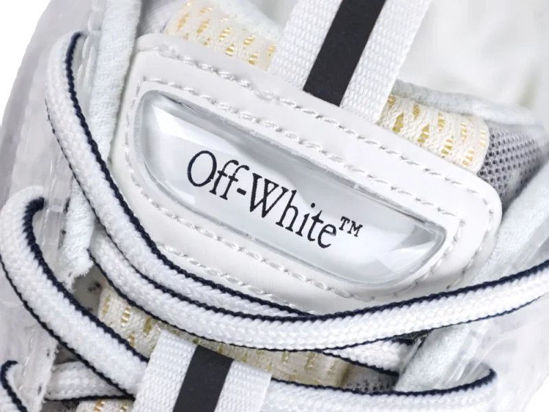 Close-up of a white sneaker tongue with black logo text and lace detail.