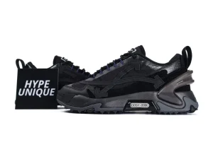 Black sneakers with suede and mesh materials, featuring a chunky sole and detailed design.