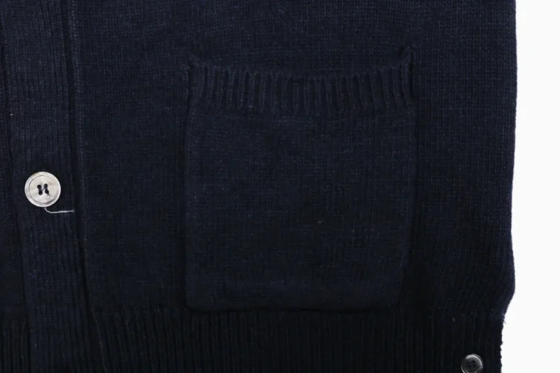 Front pocket detail on navy knit cardigan.