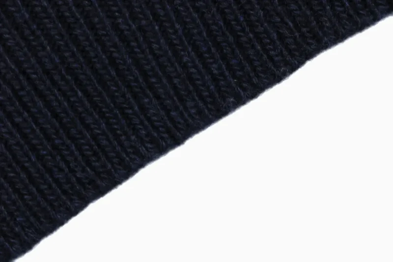 Ribbed hem knit detail on navy cardigan.
