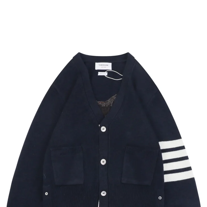 Navy wool cardigan with white striped sleeve and front pockets, button closure.