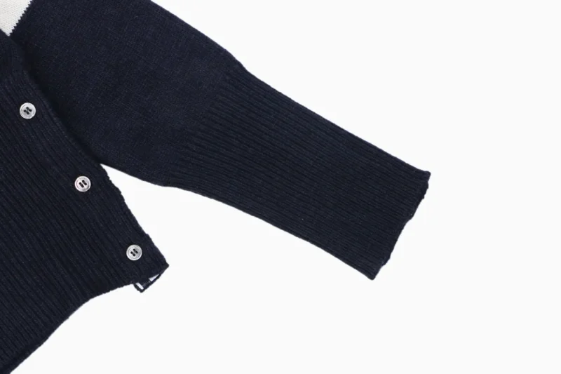 Navy knit cardigan sleeve with ribbed cuff and button front detail.