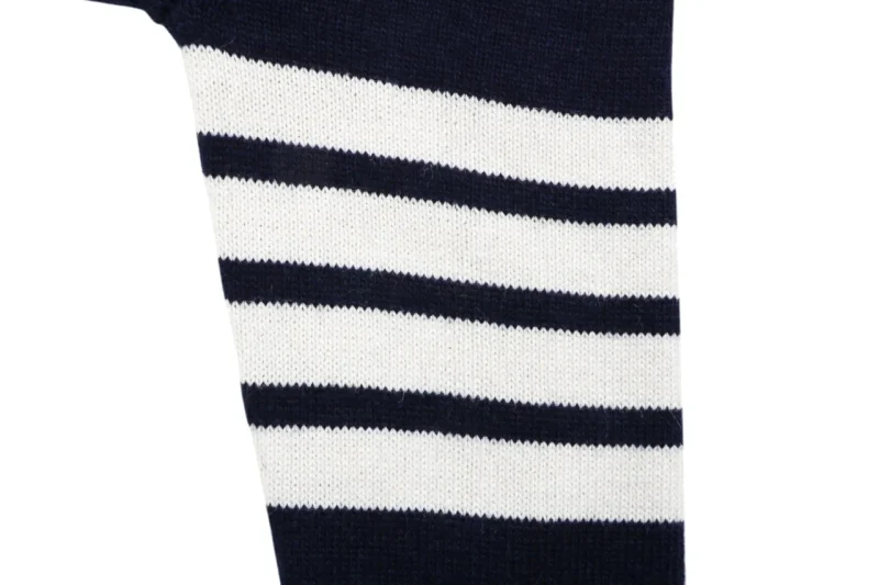 Four-bar stripe detail on navy knit cardigan sleeve.