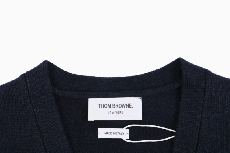 Thom Browne New York label and Made in Italy tag on navy knit cardigan.