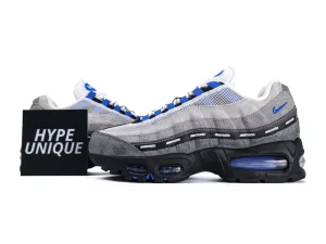 Gray and blue sneakers with suede material and mesh upper, featuring bold branding.