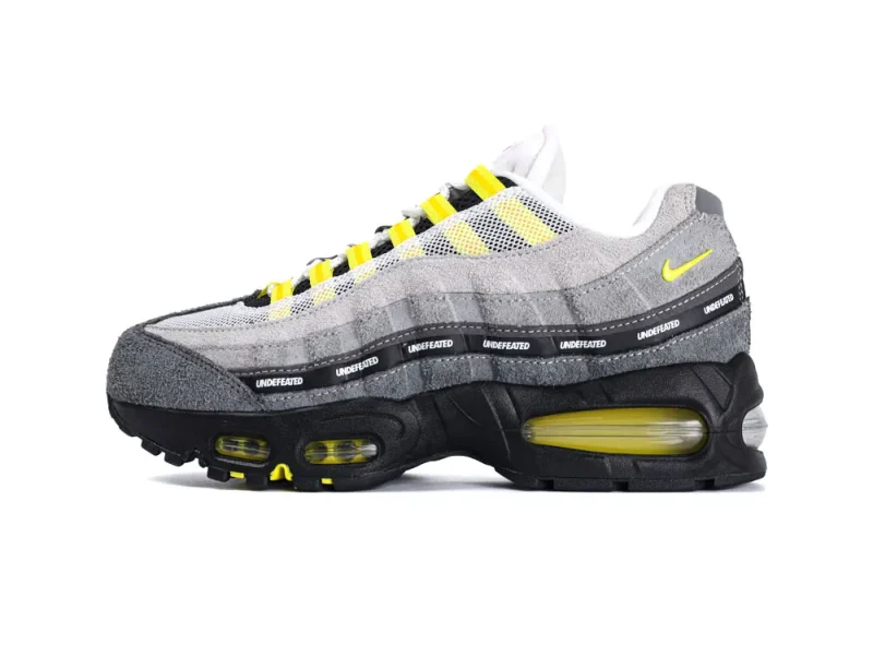 Gray suede and mesh sneaker with yellow accents and a black rubber sole.