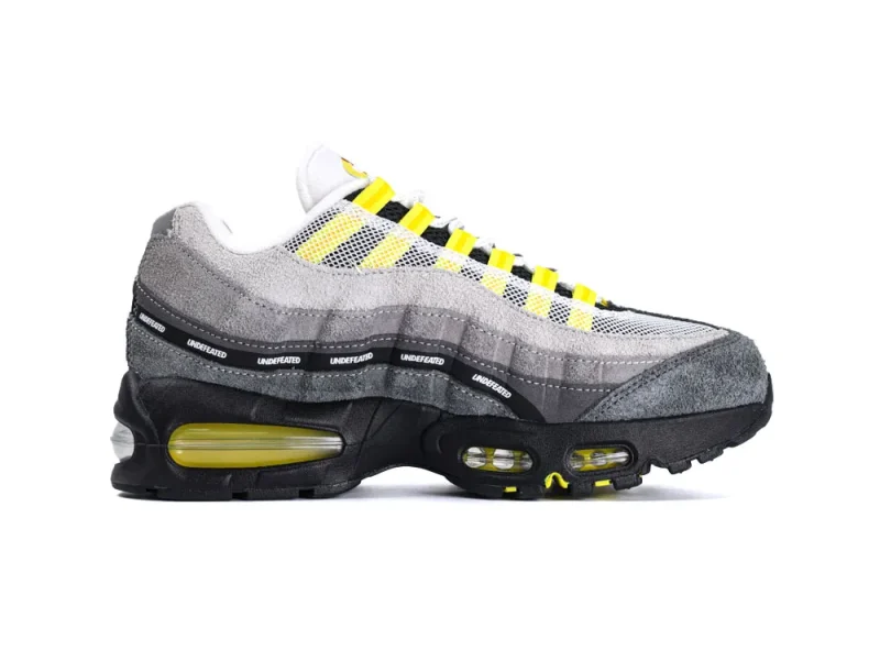Gray and yellow sneaker with suede overlay, mesh upper, and black rubber sole.