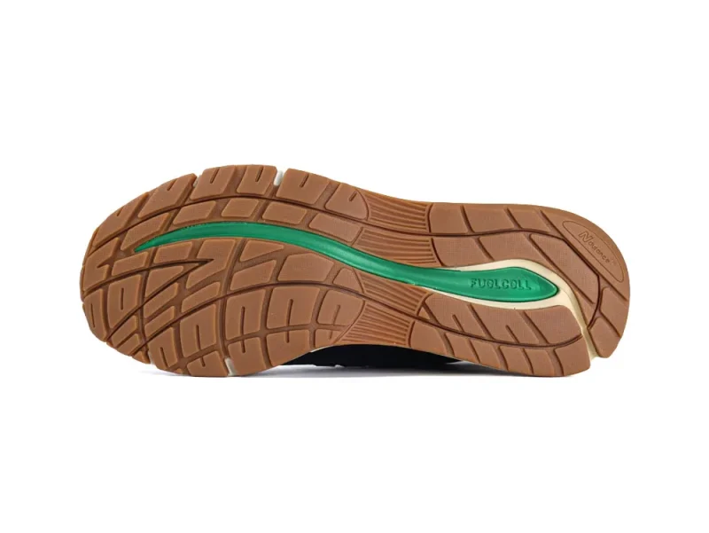 Brown rubber shoe sole with green accents and groove patterns for grip.