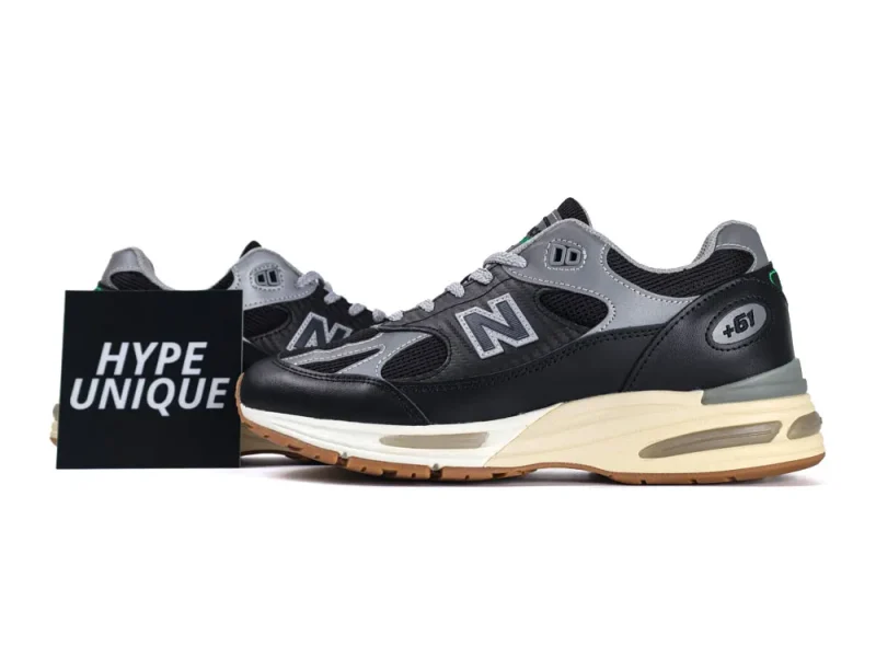 Gray and black sneakers with leather and mesh material, featuring cushioned beige sole.